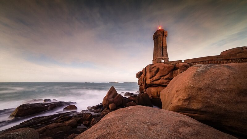 Lighthouse on Rocky Coast — Brown, Dramatic