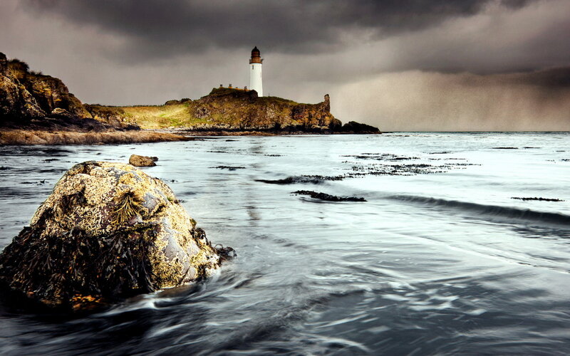 Lighthouse on Rocky Coast — Gray, Dramatic, Photograph