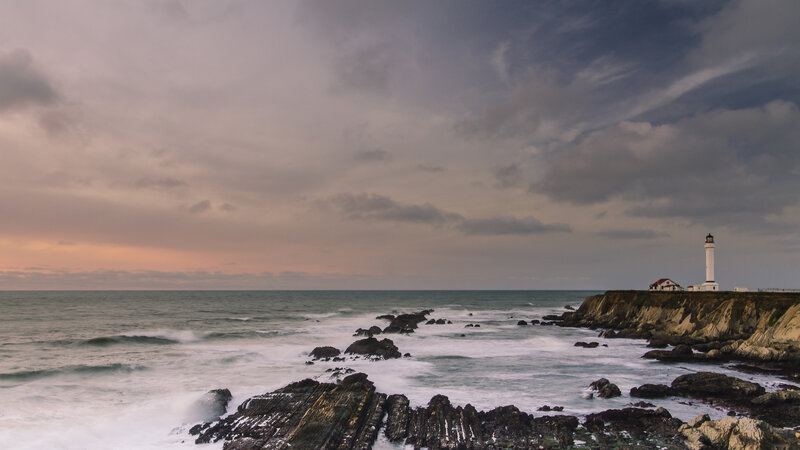 Lighthouse on Rocky Coast — Gray, Dramatic, Sunset, Photograph, Ocean, Rocks