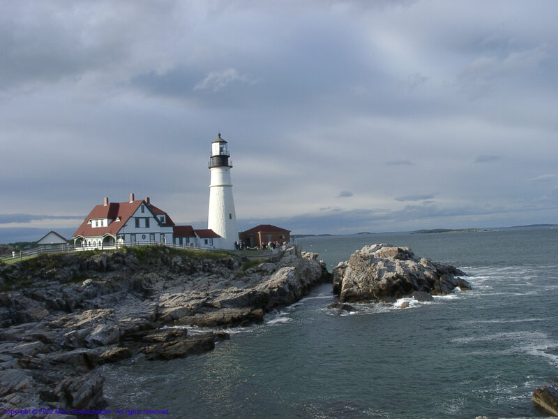 Lighthouse on Rocky Coast — Gray, Dramatic