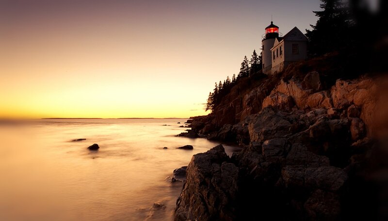 Lighthouse on Rocky Coast — Orange, Serene, Sunset, Photograph, Ocean, Rocks, Trees