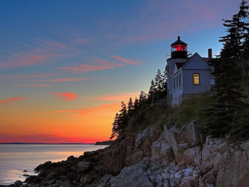 Lighthouse on Rocky Coast — Orange, Serene, Sunset, Photograph