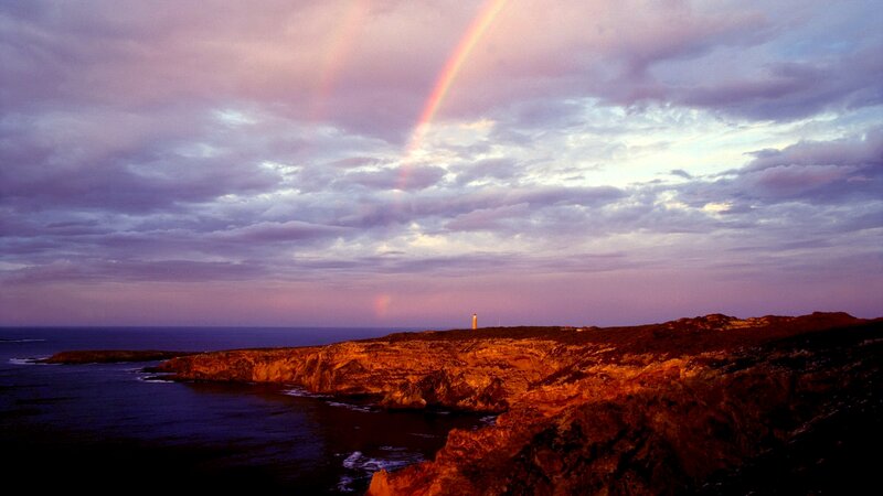 Lighthouse on Rocky Coast — Purple, Dramatic, Sunset, Photograph, Rainbow