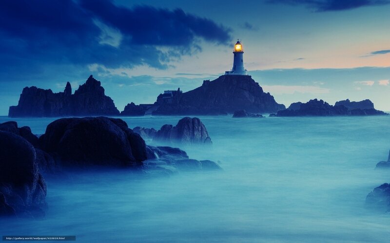 Lighthouse on rocky island at dusk