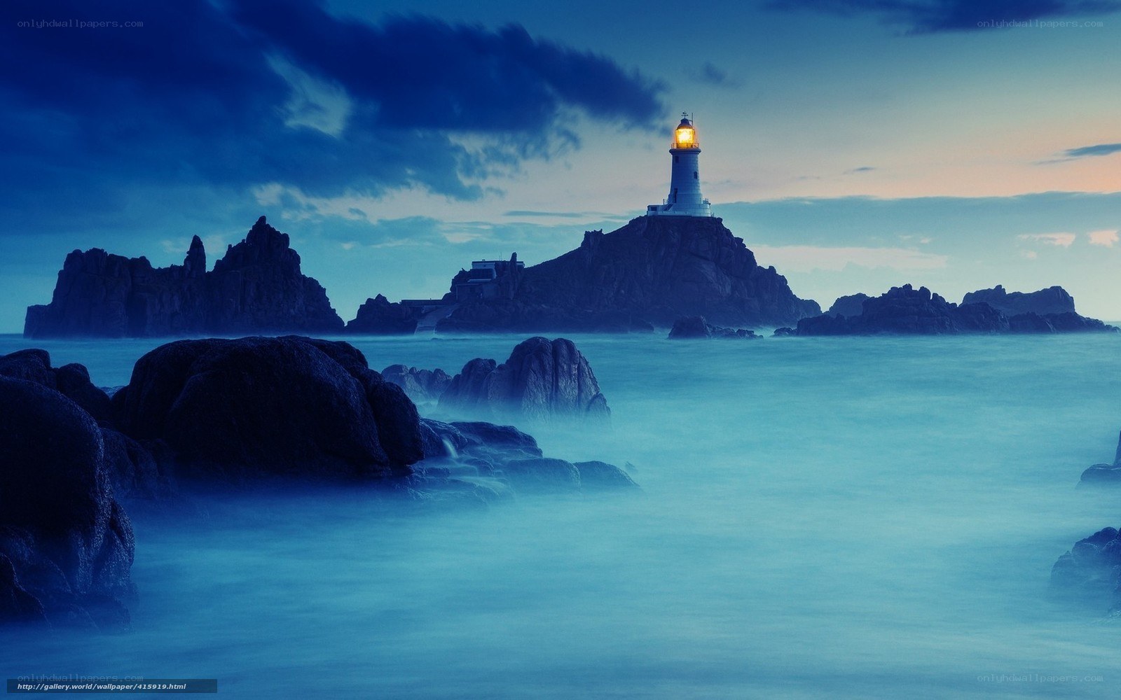 Lighthouse on rocky island at dusk