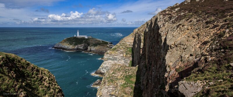 Lighthouse on Rocky Island — Blue, Dramatic, Afternoon, Photograph, Ocean, Cliffs