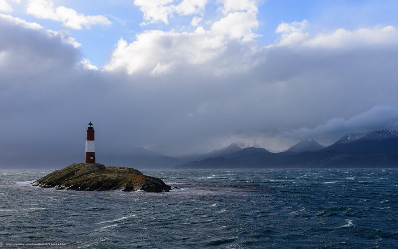 Lighthouse on Rocky Island — Blue, Dramatic, Photograph, Sea, Mountains