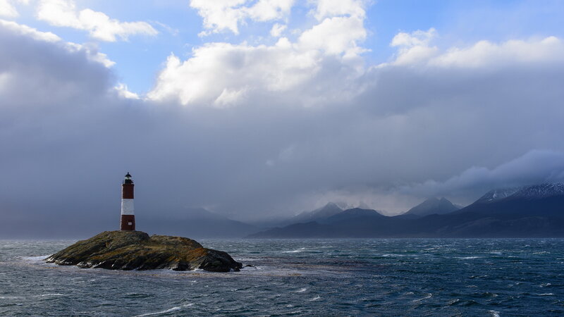 Lighthouse on Rocky Island — Blue, Dramatic, Photograph, Sea