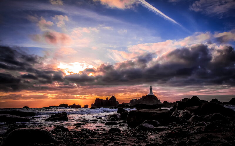 Lighthouse on Rocky Island — Blue, Dramatic, Sunset, Photograph, Clouds