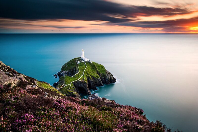 Lighthouse on Rocky Island — Blue, Dramatic, Sunset, Photograph, Ocean, Sky, Flowers