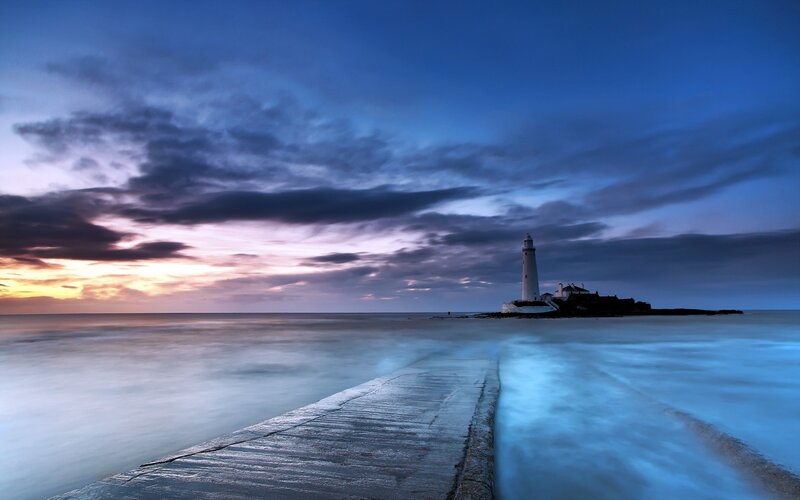 Lighthouse on Rocky Island — Blue, Dramatic, Sunset, Photograph, Pier