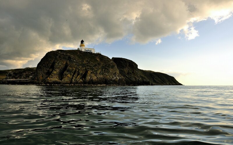 Lighthouse on Rocky Island — Blue, Dramatic, Sunset, Photograph, Sea, Clouds