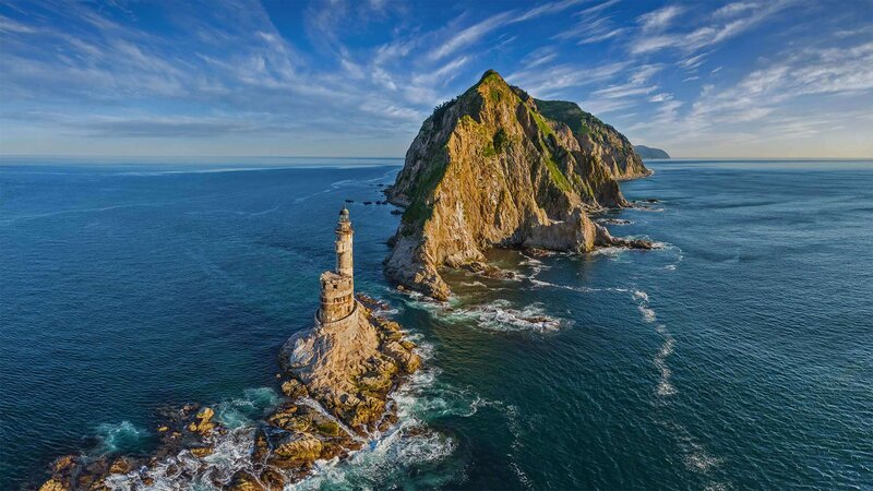 Lighthouse on Rocky Island — Blue, Serene, Afternoon, Photograph, Ocean, Cliffs, Sky
