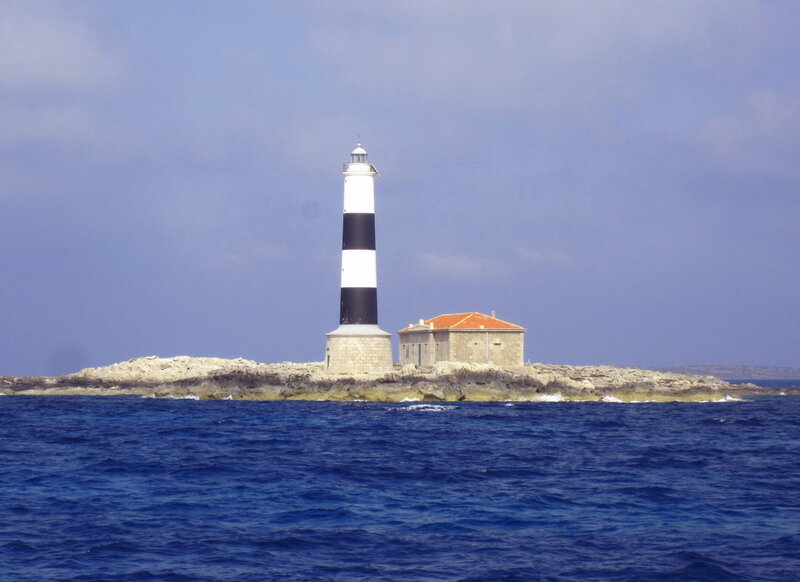 Lighthouse on Rocky Island — Blue, Serene, Afternoon, Photograph, Ocean, Sky