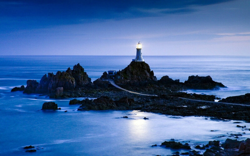 Lighthouse on Rocky Island — Blue, Serene, Night, Photograph, Ocean, Rocks, Path