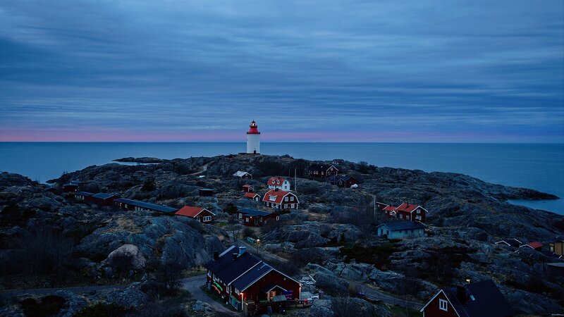 Lighthouse on Rocky Island — Blue, Serene, Sunset, Photograph, Houses