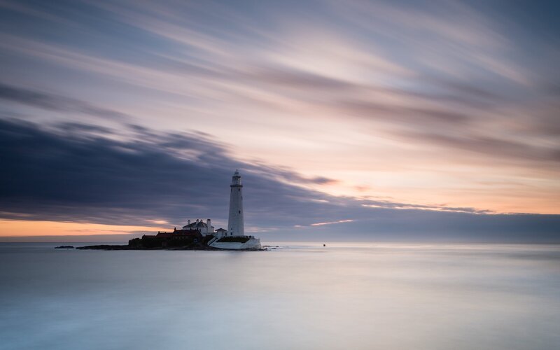 Lighthouse on Rocky Island — Blue, Serene, Sunset, Photograph, Sea