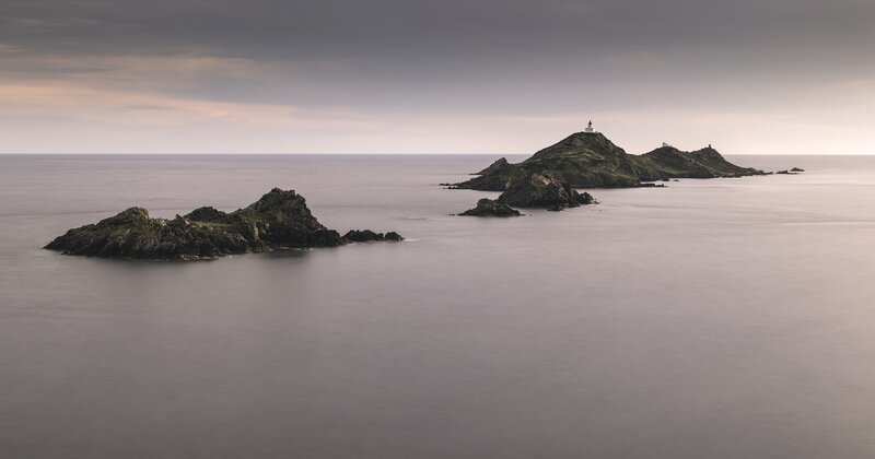 Lighthouse on Rocky Island — Gray, Serene, Sunset