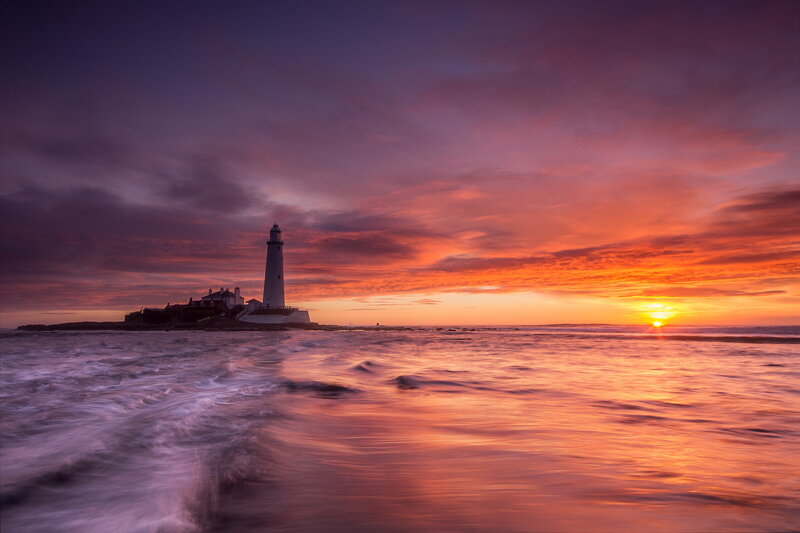 Lighthouse on Rocky Island — Orange, Dramatic, Sunset, Photograph, Sun