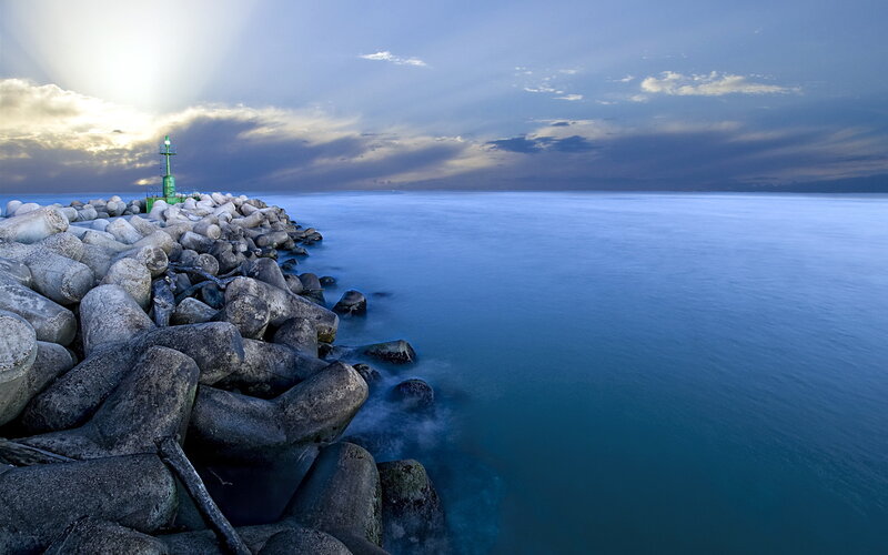 Lighthouse on Rocky Pier — Blue, Serene, Sunset, Photograph