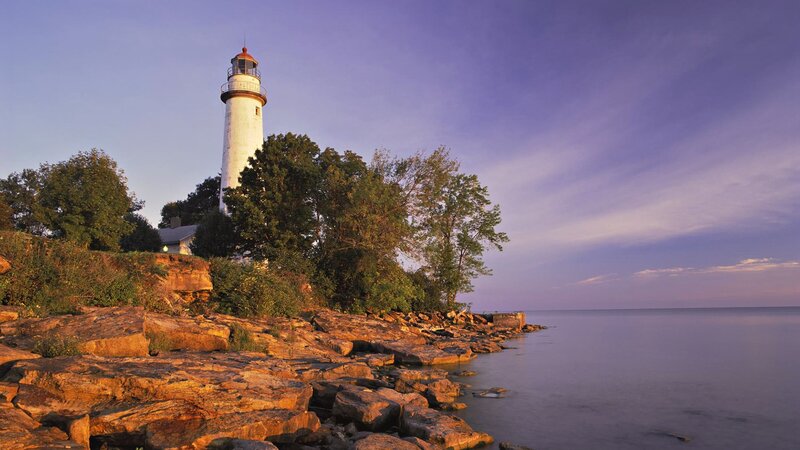 lighthouse on rocky shore at dusk