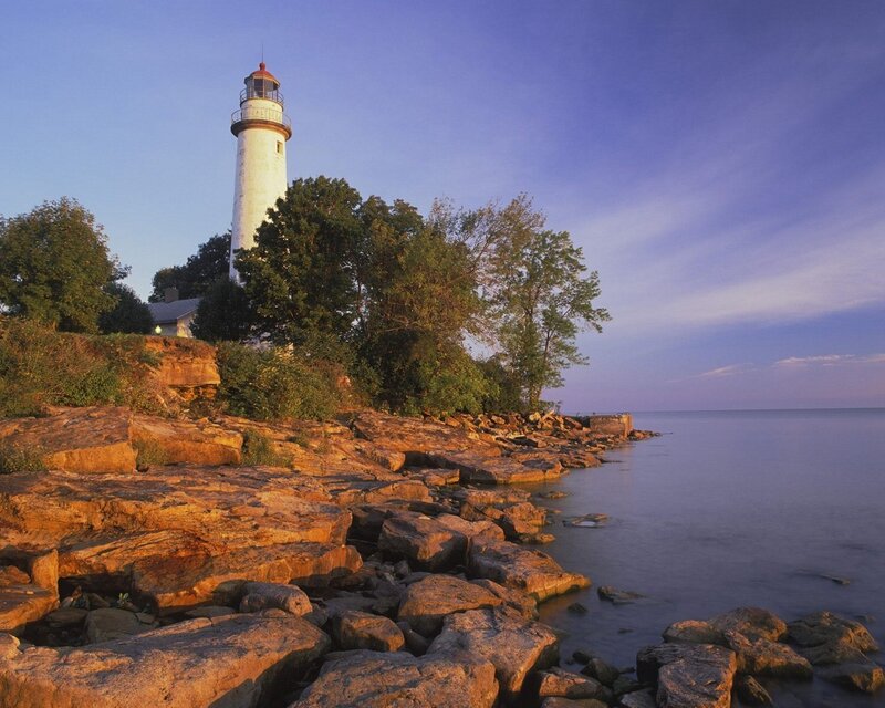 lighthouse on rocky shore at dusk