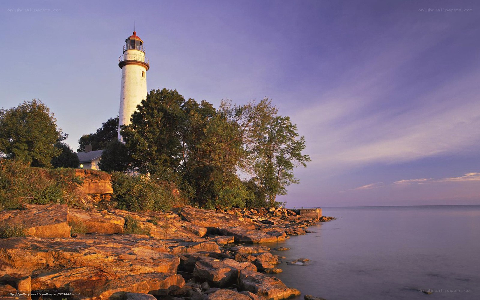 Lighthouse on rocky shore at dusk