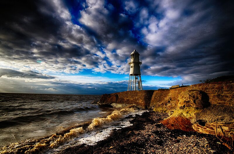 Lighthouse on Rocky Shore — Blue, Dramatic, Afternoon, Photograph, Ocean