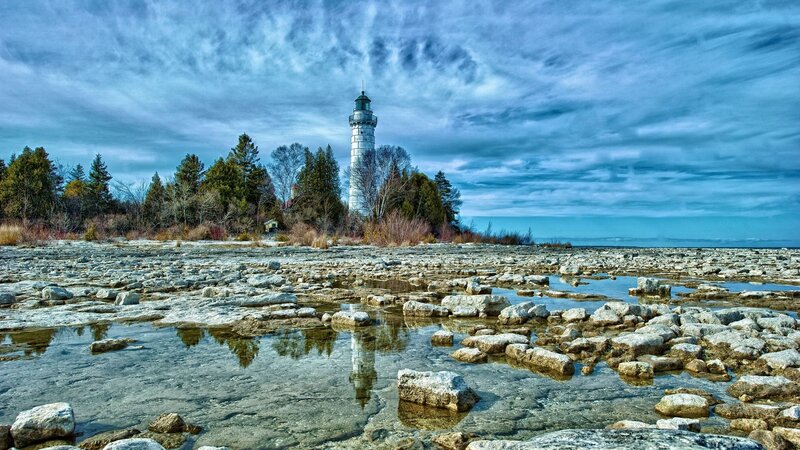 Lighthouse on Rocky Shore — Blue, Dramatic, Afternoon, Photograph, Trees