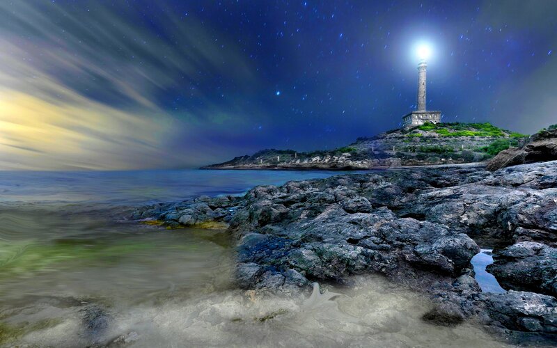 Lighthouse on Rocky Shore — Blue, Dramatic, Night, Photograph, Sea