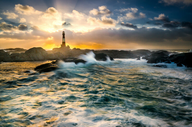 Lighthouse on Rocky Shore — Blue, Dramatic, Sunset, Photograph, Ocean Waves, Rocks