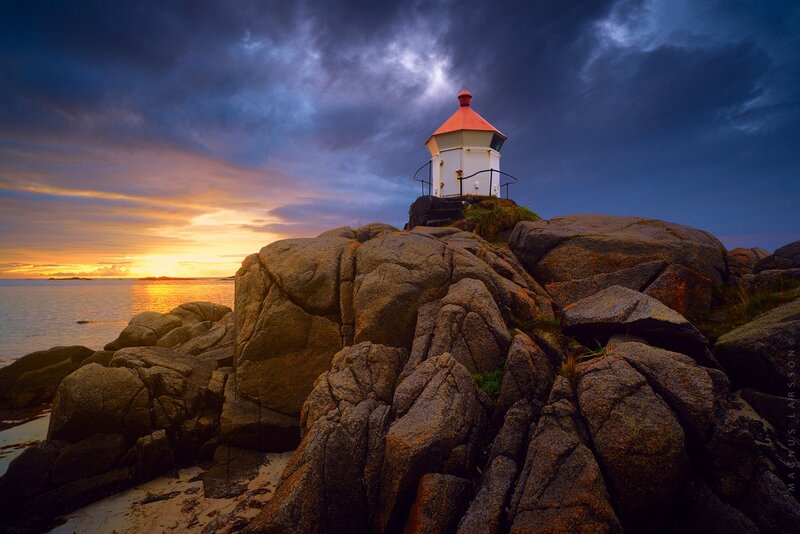 Lighthouse on Rocky Shore — Blue, Dramatic, Sunset, Photograph, Rocks, Sea