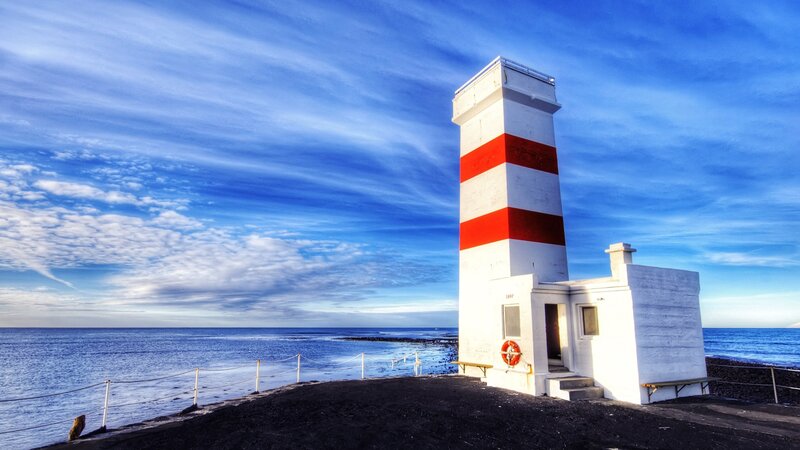 Lighthouse on Rocky Shore — Blue, Serene, Afternoon, Photograph, Ocean, Sky, Bench