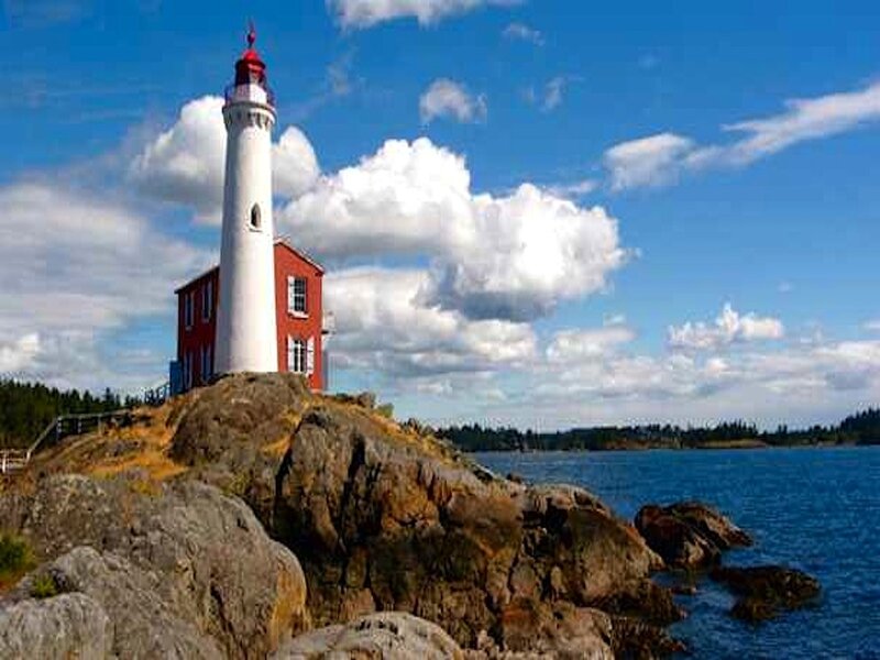 Lighthouse on Rocky Shore — Blue, Serene, Afternoon, Photograph, Ocean
