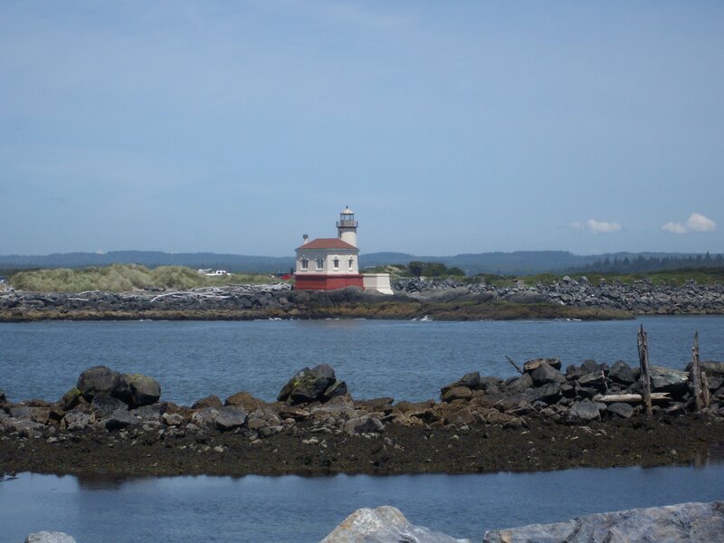 Lighthouse on Rocky Shore — Blue, Serene, Afternoon, Photograph, Rocks, Water