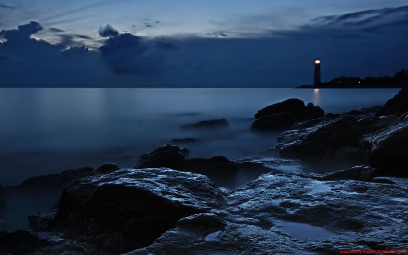 Lighthouse on Rocky Shore — Blue, Serene, Night, Photograph, Rocks, Sea, Clouds