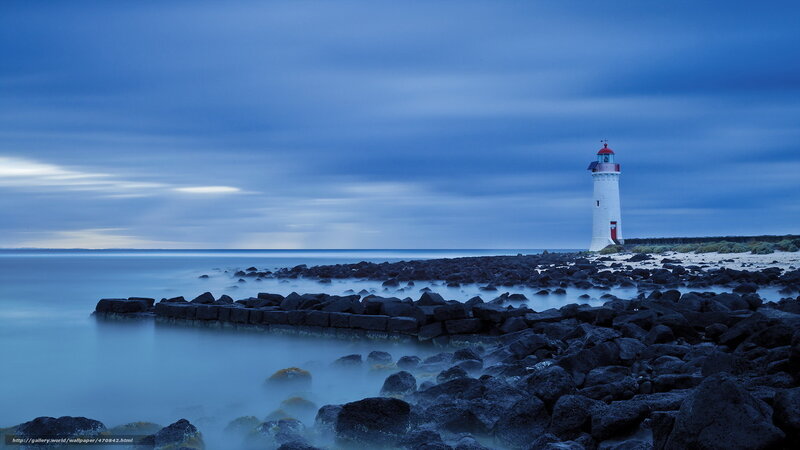 Lighthouse on Rocky Shore — Blue, Serene, Night, Photograph, Rocks, Sea, Sky, Black