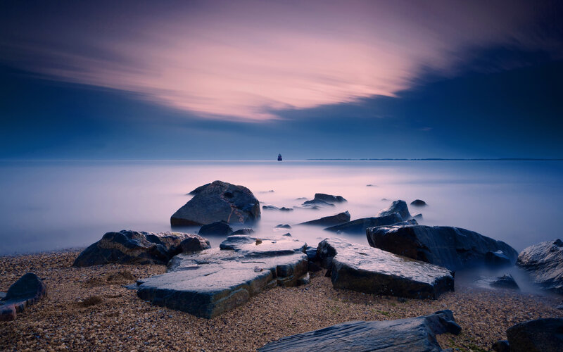 Lighthouse on Rocky Shore — Blue, Serene, Sunset, Photograph, Rocks, Sea, Sky