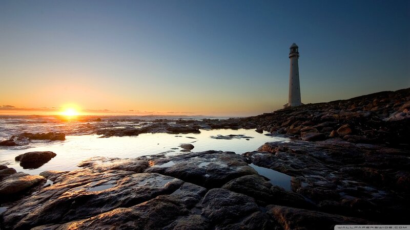Lighthouse on Rocky Shore — Blue, Serene, Sunset, Photograph, Sunrise