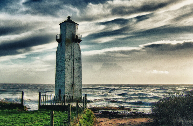 Lighthouse on Rocky Shore — Gray, Dramatic, Photograph