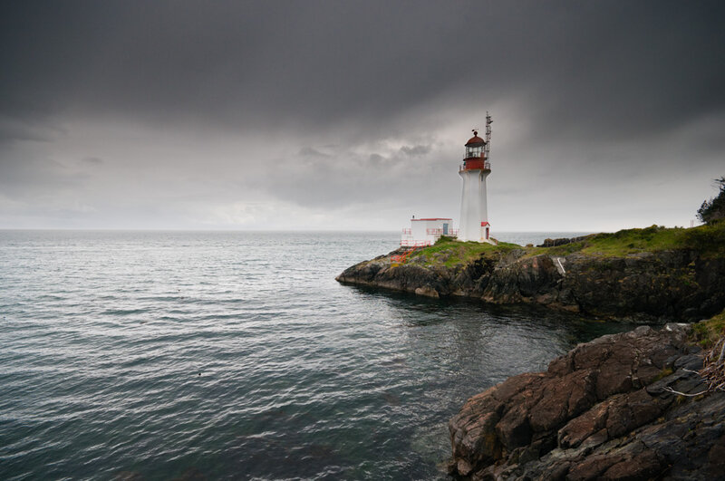 Lighthouse on Rocky Shore — Gray, Dramatic