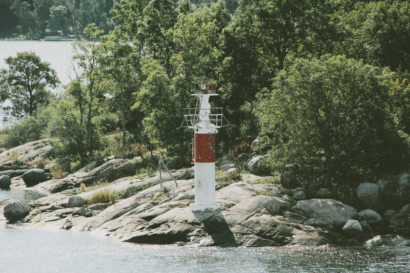 Lighthouse on Rocky Shore — Green, Serene, Afternoon