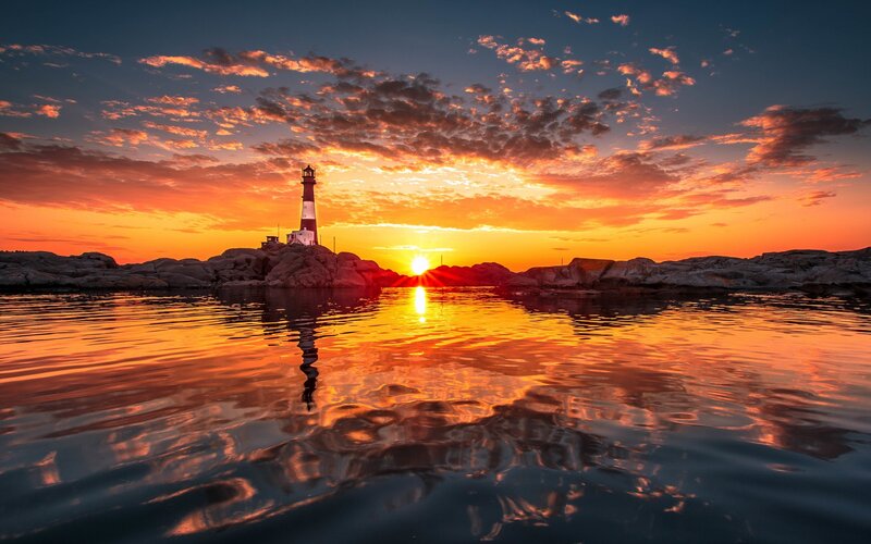 Lighthouse on Rocky Shore — Orange, Dramatic, Sunset, Photograph, Sun, Sky