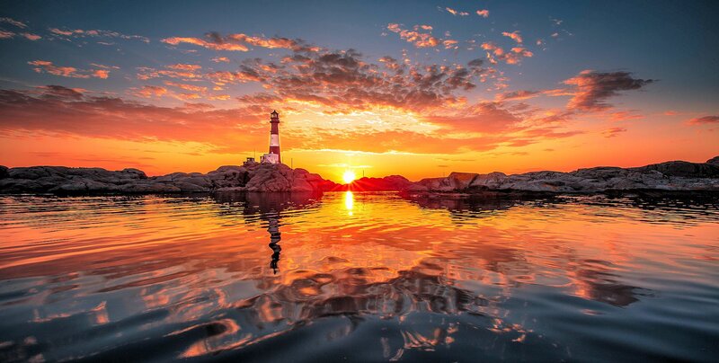 Lighthouse on Rocky Shore — Orange, Dramatic, Sunset, Photograph, Sun