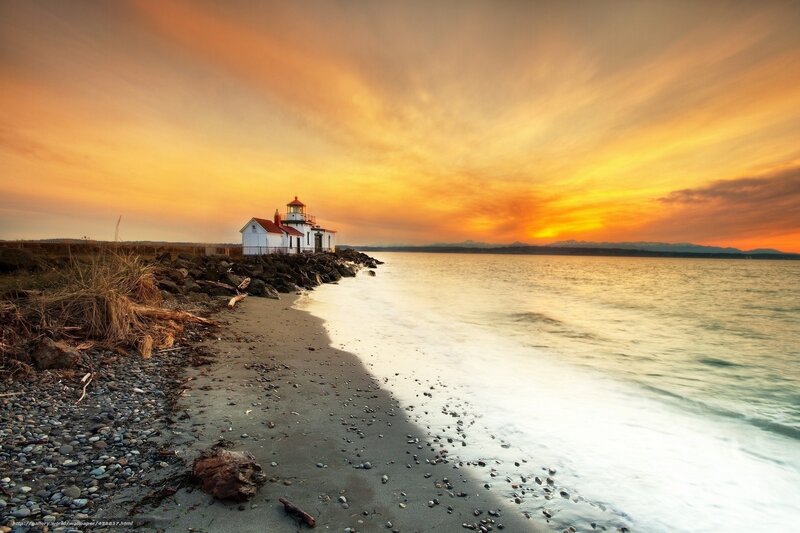 Lighthouse on Rocky Shore — Orange, Serene, Sunset, Photograph, Ocean, Sky, Mountains