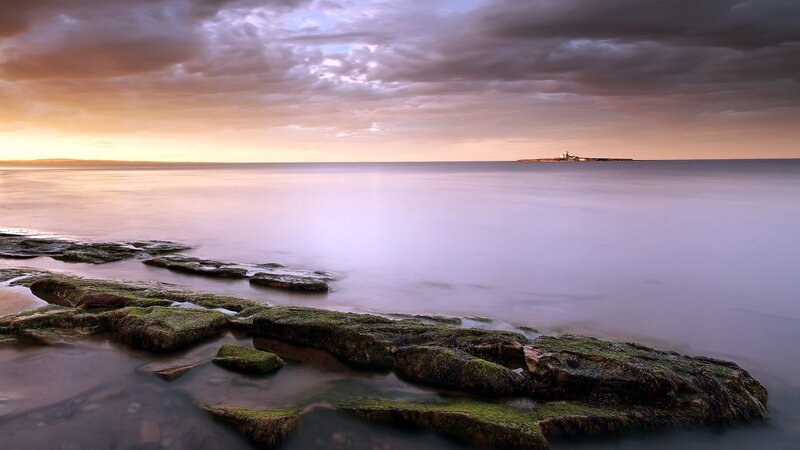 Lighthouse on Rocky Shore — Purple, Serene, Sunset, Photograph, Rocks, Sea, Sky