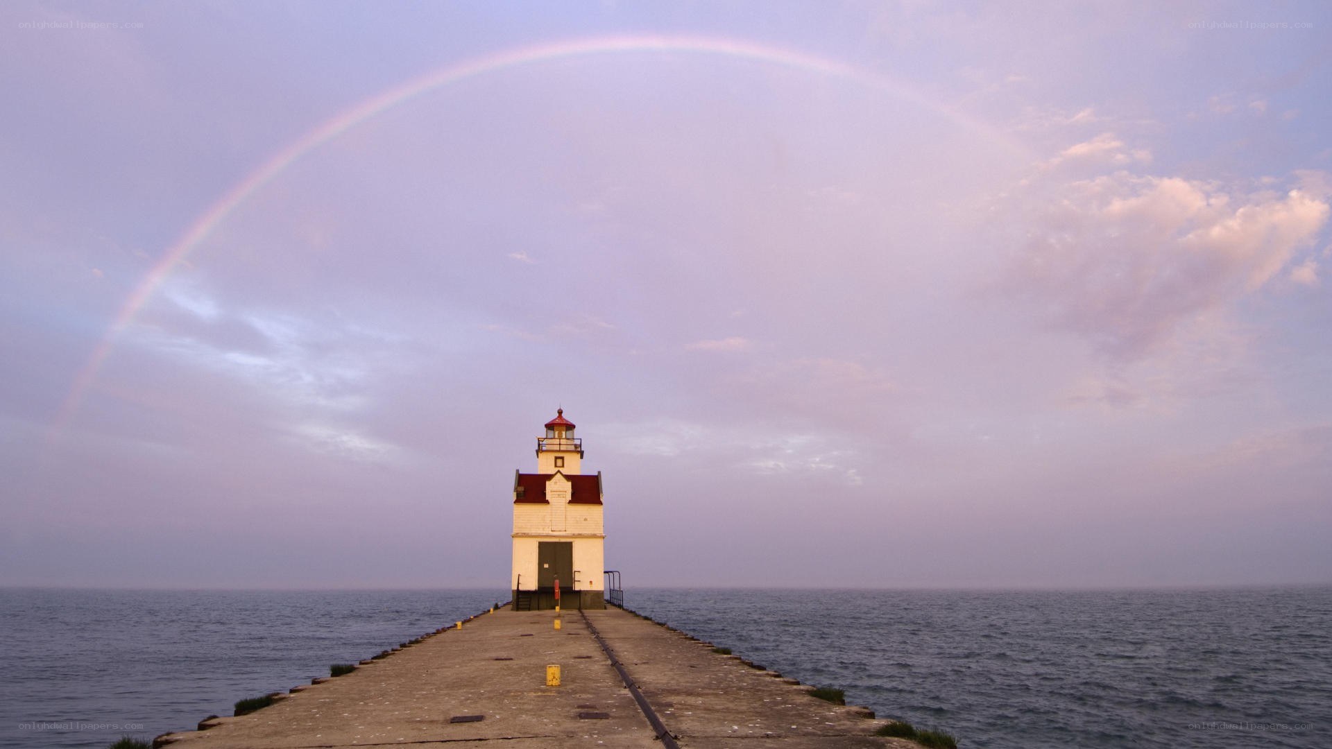 lighthouse with rainbow over water