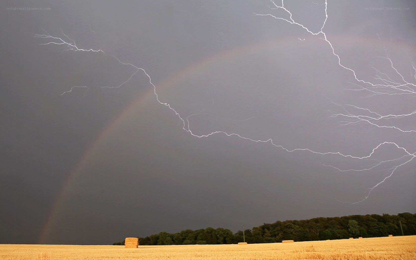 Lightning and rainbow over field