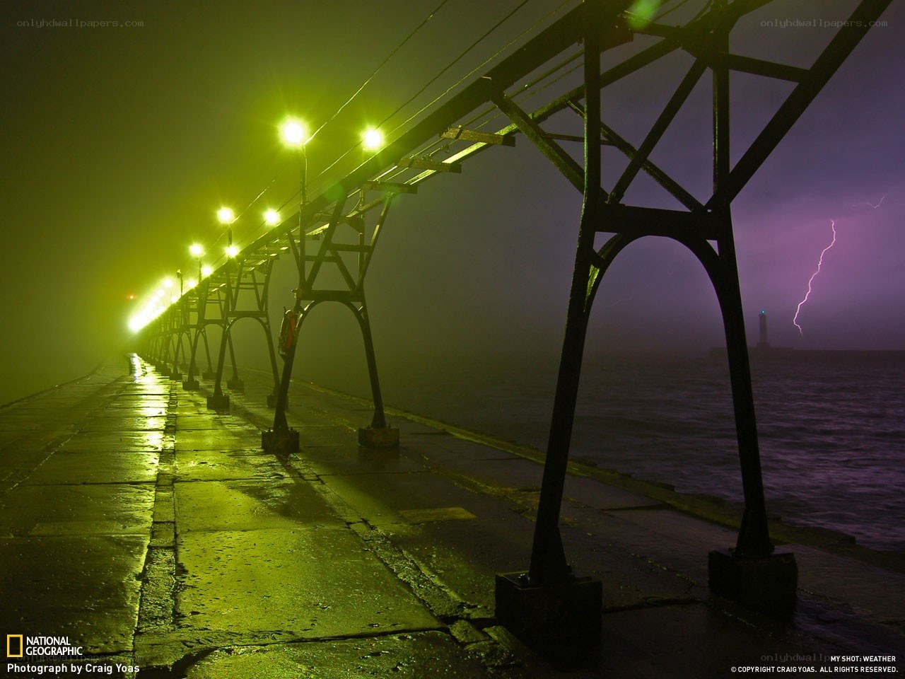 Lightning over a foggy pier