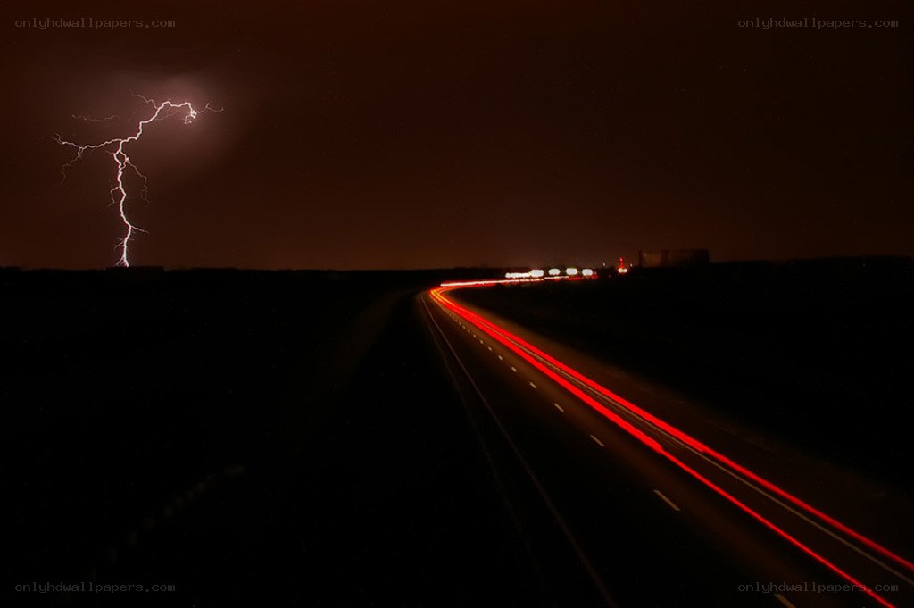 Lightning over a highway at night